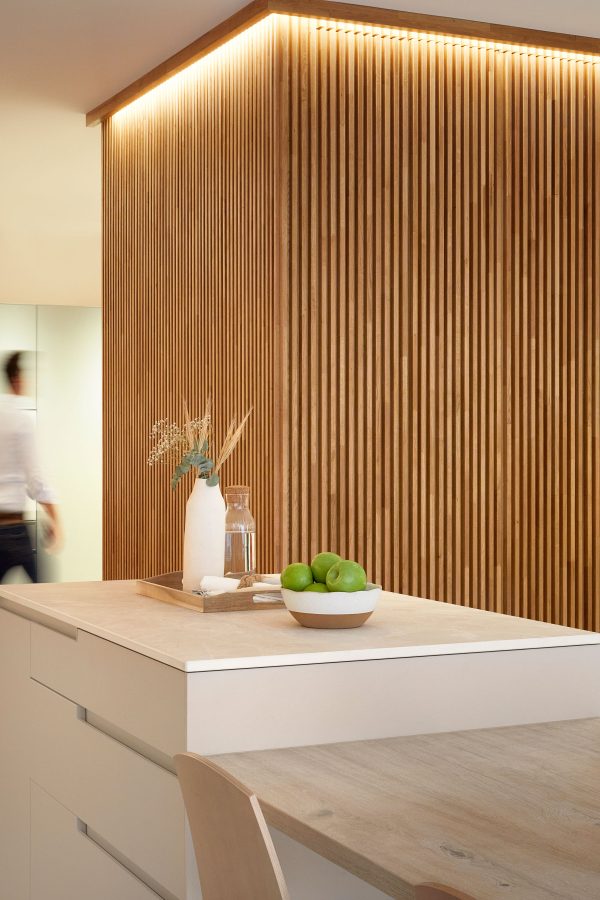 Cocina revestida en panel de madera con isla central — Reformas Compás